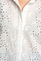 Blusa blanca de manga larga con cuello camisero, confeccionada en algodón con bordados calados (broderie) de diseño floral y arabesco.