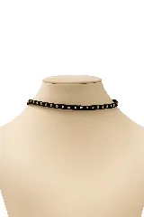 Gargantilla tipo choker de gamuza negra con tachas plateadas.