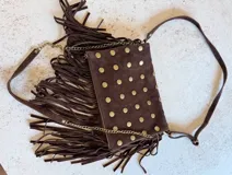 Bandolera marrón de gamuza con flecos y tachas doradas.