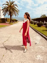 Vestido de fiesta fucsia con escote y espalda de cuero, tajos laterales con hilo metálico y terminación con flecos.
