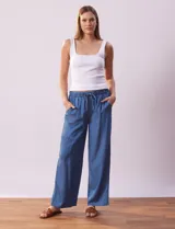Pantalón largo de lyocell color azul, corte ancho, con pretina elastizada con lazo de ajuste, bolsillos laterales y delanteros tipo cargo.
