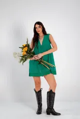 Vestido corto verde esmeralda con bordado calado, escote en V, sin mangas y corte evasé.
