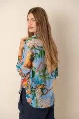 Camisa celeste con estampado de motivos tropicales, de corte clásico y manga larga.