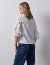 Blusa de gasa blanca, marca Sioni, con mangas 3/4 y aplique de volados.