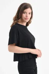 Camiseta negra de algodón orgánico con mangas cortas y volados en el ruedo.