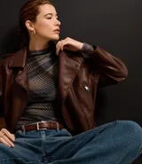 Blusa de tul de manga larga con cuello alto y estampado de cuadros escoceses en tonos marrones, azules y grises.