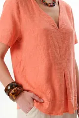Blusa color salmón de lino con escote en V y mangas cortas.