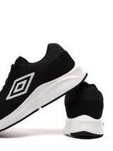 Championes Umbro modelo Volcan, color negro con detalles en blanco. Presentan un diseño deportivo con capellada de tela y gamuza, entresuela blanca gruesa y el logo Umbro en el lateral.