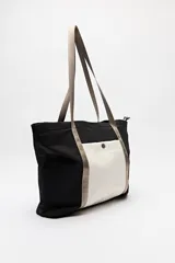 Bolso tipo tote de nylon color negro con bolsillo frontal blanco y asas largas color beige.