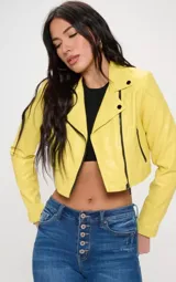 Chaqueta corta de cuero vegano color amarillo con cierre cruzado y detalles en negro.