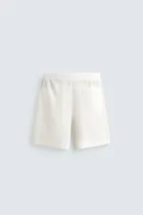 Bermuda negra de lino con calce relajado. Presenta cintura elástica ajustable con cordón, bolsillos frontales y un bolsillo trasero de plastrón.