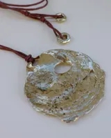 Collar con dije grande de bronce con forma de ostra y cordón de algodón ajustable color gris.