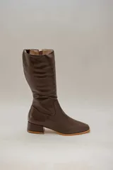 Bota de caña alta de cuero color rojo, con cierre lateral y taco cuadrado de 4 cm.