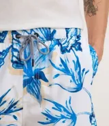 Bermuda de baño masculina en microfibra blanca con estampado de caracolas en tonos azules. Cuenta con cintura elástica ajustable con cordón y bolsillos laterales.