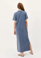 Vestido largo azul con corte recto, cuello redondo y mangas cortas. Presenta aberturas laterales en el ruedo.