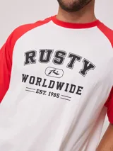 Remera azul marino con mangas raglán color crema y estampado frontal con el logo de Rusty en blanco.