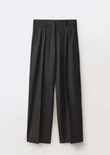 Pantalón negro de vestir, corte wide leg, con pinzas delanteras, trabillas y cinturón fino con hebilla metálica.