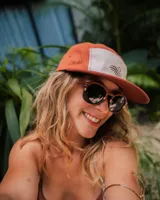 Lentes de sol con montura redonda de madera color marrón con detalles en beige y lentes grises.