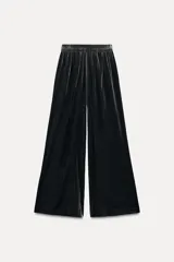 Pantalón de terciopelo negro de tiro medio con cintura elástica, bolsillos laterales ocultos y pierna ancha.