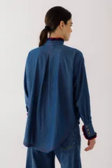 Camisa de jean azul con cuello mao, mangas largas y bolsillo de crochet en el pecho.
