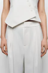 Pantalón de tiro alto color blanco, de corte recto y pierna ancha, con bolsillos laterales y pinzas frontales.