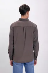 Camisa marrón de micropana con cuello abotonado, manga larga y bolsillo en el pecho.