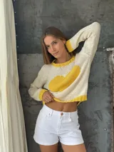 Sweater tejido a mano en Uruguay, 100% lana merino color crudo, con cuello, puños y ruedo en amarillo. Presenta un corazón amarillo en el frente.
