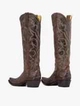 Bota texana de cuero marrón envejecido, caña alta con bordados decorativos en hilo turquesa y punta afilada. Posee un taco medio y bajo.