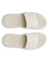 Sandalia tipo slide para hombre, color blanco hueso o crema, con tira ancha ajustable mediante velcro. La tira presenta un logo en relieve. La plantilla es texturizada para mayor confort y la suela es gruesa.