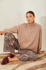 Sweater negro oversize de tejido de punto, con cuello alto y detalle de costuras a la vista.