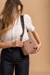 Bandolera pequeña de textura símil cuero color caramelo/marrón, con dos compartimentos principales con cierre. Correa ancha ajustable de tela negra con inscripción en relieve.