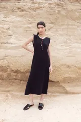 Vestido midi color crudo, de corte recto y sin mangas.