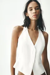 Chaleco blanco con cuello halter y escote en pico. Cierre frontal con botones.