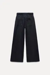 Pantalón de jean azul oscuro, corte wide leg, tiro alto, con cinturón de la misma tela y hebilla metálica.