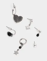 Set de aros plateados con distintos pasantes y argollas con dijes de estrella, corazón y cuentas negras.