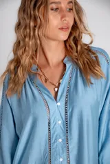 Vestido corto celeste con mangas 3/4 acampanadas y detalle de puntilla en mangas y ruedo.