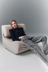 Jean tiro alto de denim negro rígido, lavado gris localizado con bigotes, pierna recta y apliques laterales de lentejuelas o tachas.