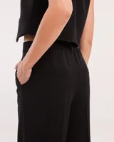 Pantalón sastrero corte palazo con elástico en la pretina trasera, cierre delantero y broche interno.