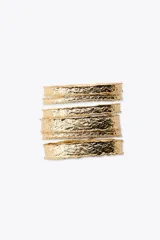 Pack de pulseras rígidas doradas con textura irregular.