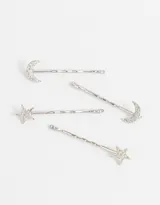 Set de cuatro horquillas doradas para el pelo, dos con apliques de luna y dos con apliques de estrella.