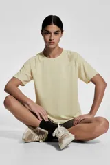Remera deportiva color crema de tejido funcional con tecnología DryMove™, corte holgado, cuello redondo y mangas cortas raglán.