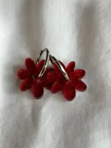 Aros colgantes plateados con dije de flor acrílica color dorado.