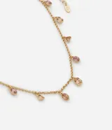 Collar corto dorado con cadena de eslabones y colgantes de piedras facetadas en tonos rosa y naranja.