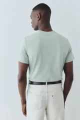 Remera verde agua de punto liviano con cuello redondo ribeteado y bajo recto. Corte estándar confeccionada con COOLMAX®, fibra sintética que transporta el sudor del cuerpo a la superficie del tejido.