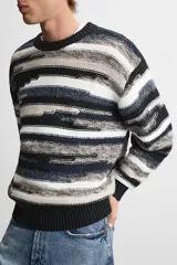 Jersey de hombre con corte relaxed, cuello redondo y manga larga. Diseño con patrón geométrico jacquard en tonos negro, gris y blanco.