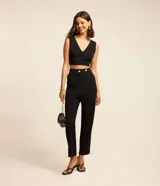 Pantalón zanahoria de crepé negro, con cintura alta y triple abotonadura metálica.