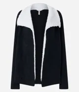 Cardigan alargado color blanco, con cuello virada, forro de pelos y confeccionado en punto pesado. No tiene cierre.