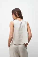 Musculosa color crudo con textura laminada, de corte recto y sin mangas.