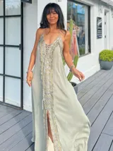 Vestido largo color verde agua con escote halter y abertura frontal. Decorado con bordados de lentejuelas plateadas y doradas.