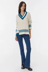 Sweater de estilo clásico color crudo, con cuello en V y diseño de puntos texturizados en el cuerpo y las mangas.